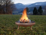 Eine brennende Feuerschale auf einer Wiese